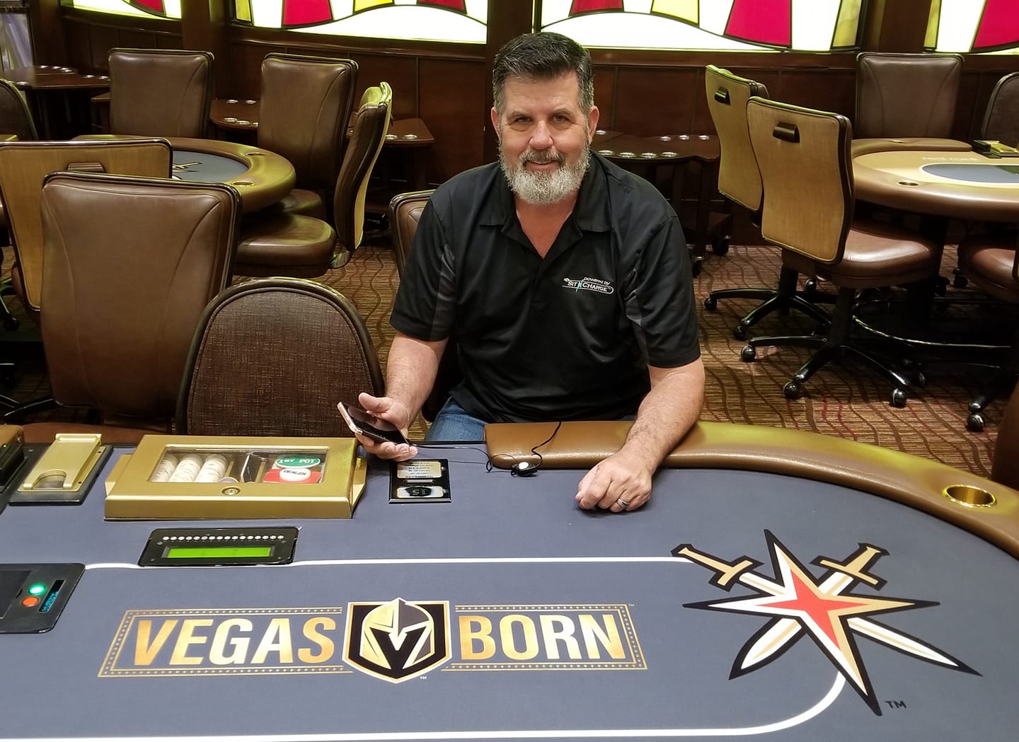 SitNCharge founder Dave Redden at a poker table showing the product in action